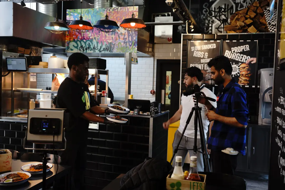 YBO crew filming inside Burger Daddy with a camera on a tripod